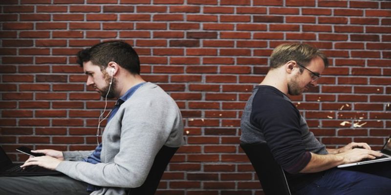 Two Men Working On Personal Devices