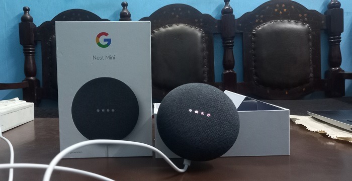 Four white lights flashing and fading away on Google Nest Mini speaker. 