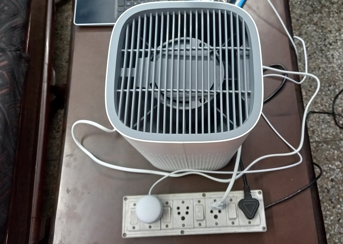 Air purifier powered on in outlet with fan moving.