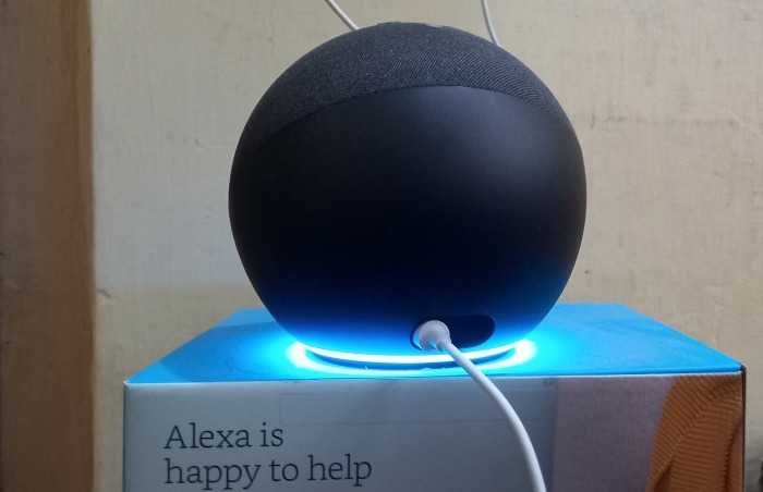 Amazon Echo speaker in listening mode with blue lights on to connect Alexa. 