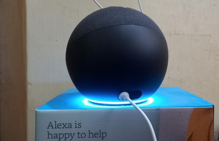Amazon Echo speaker in listening mode with blue lights on to connect Alexa.
