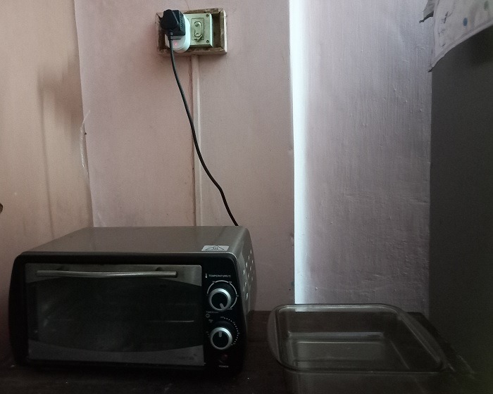 Smart plug connected to non-smart oven and powered on with blinking lights.