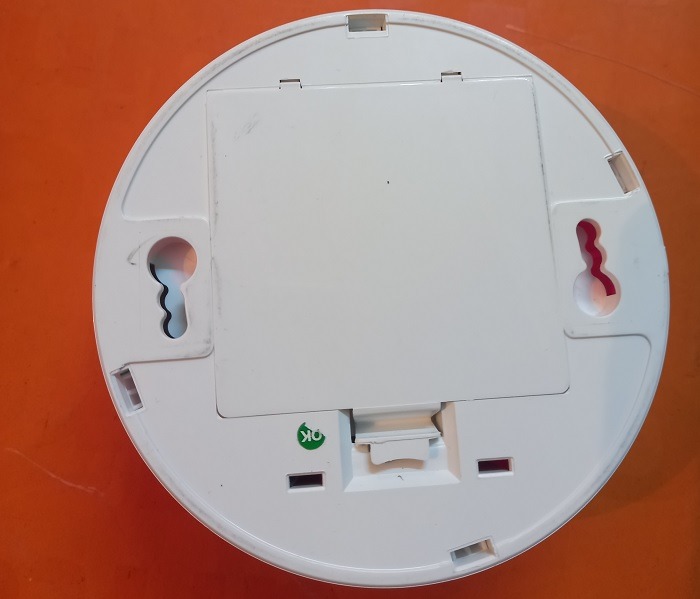 Open bottom battery cover of a wireless smoke detector.